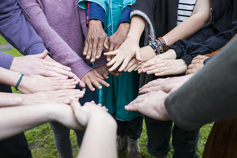 Lehrgang Grundkurs Jugendarbeit-(c)-Carolina Frank-_FR_3995 Hände, weiß und of colour, von jungen und älteren Leuten, in einem Kreis aneinander gehalten
